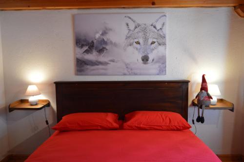 a bedroom with a red bed with a picture of a wolf at Maison Chez Les Roset in Arvier
