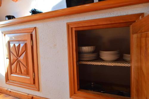 a cabinet with plates and bowls in it at Maison Chez Les Roset in Arvier