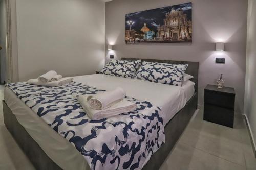 カターニアにあるVicolo 4 Apartmentのタオルが敷かれた大きなベッドのある寝室