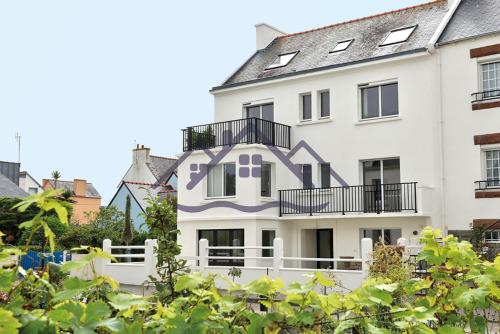 une maison blanche avec une peinture violette sur elle dans l'établissement LocaLise - M45 - La grève blanche - Maison avec jardin entièrement clos - A 50m de la plage - Linge de lit inclus - Wifi inclus - animaux non admis, au Guilvinec