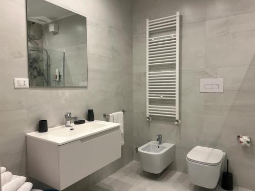 a white bathroom with a sink and a toilet at Il viandante in Sulmona