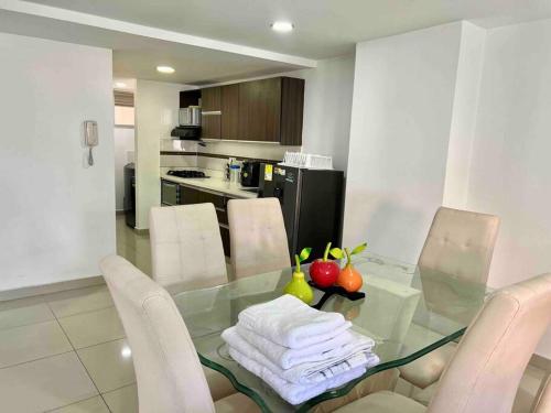 麥德林的住宿－Perfect 3BR Apartment Medellin best location，厨房配有玻璃桌和白色椅子