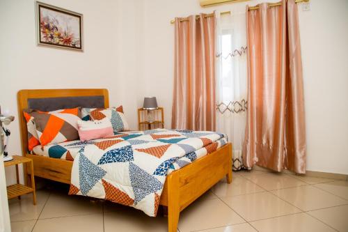 een slaapkamer met een bed met een quilt bij Luxury Home 3bed in Accra