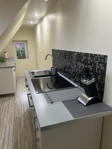 a kitchen with a sink and a counter top at Apartamenty Stokrotka in Lądek-Zdrój
