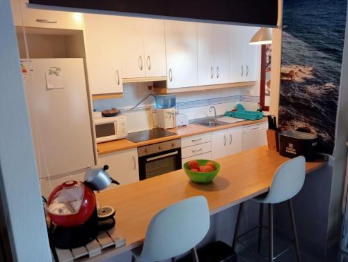 een kleine keuken met een tafel met een fruitschaal erop bij Apartamento playas de Vera con vistas al mar in Vera