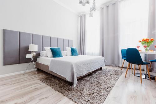 um quarto com uma cama, uma mesa e cadeiras em Erasmus Student Apartments - Old Town em Cracóvia