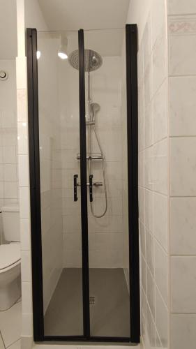 La salle de bains est pourvue d'une douche avec une porte en verre. dans l'établissement A Lazuel Aubenas, à Aubenas