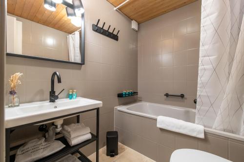 a bathroom with a sink and a bath tub at The Eiger Express Apartment - GRINDELHOMES in Grindelwald