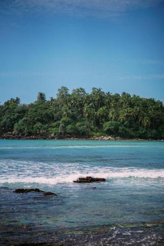 an island in the ocean with rocks in the water at Lazy Monkey Surfhostel - Sri Lanka in Hiriketiya