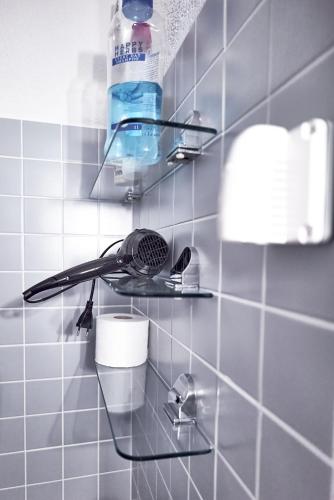 a bathroom with a rack with a hair dryer on a wall at Family room by Interlaken Parking in Därligen