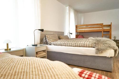 a bedroom with two beds and a desk with a lamp at Family room by Interlaken Parking in Därligen