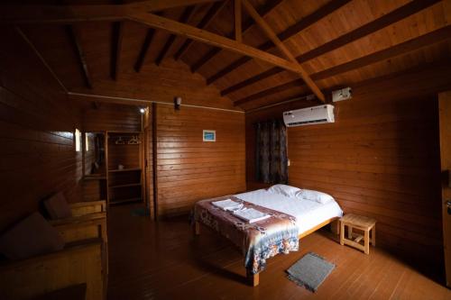 a bedroom with a bed in a wooden room at Leo Woods Hampi River view in Hampi