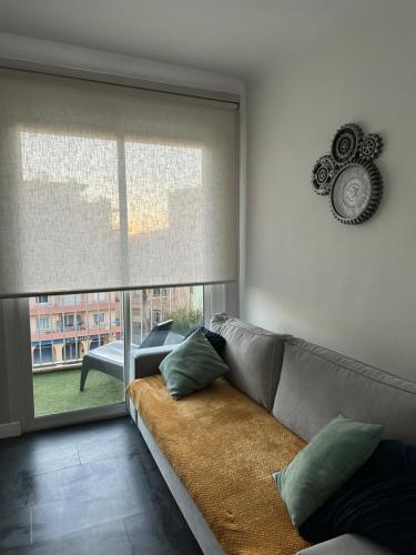uma sala de estar com um sofá e uma grande janela em MAGNIFIQUE VUE MER Place Centrale F2 45 m2 tout confort Travaux en cours sur façade em Canet-en-Roussillon