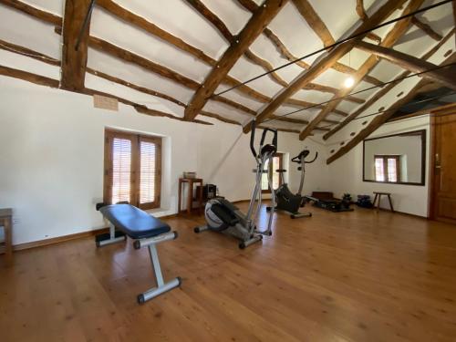 gimnasio con equipamiento de ejercicio en una sala con suelo de madera en La casona de Mahora 12 personas, en Mahora