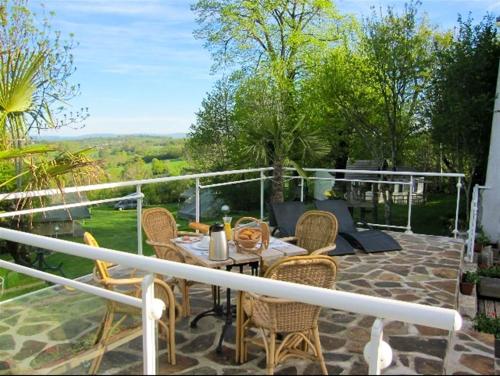 un patio con mesa y sillas en Maison de 3 chambres avec piscine partagee terrasse amenagee et wifi a Argences en Aubrac, en Banes