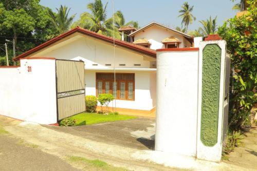 a white house with a gate in front of it at Amelia 31 in Tangalle