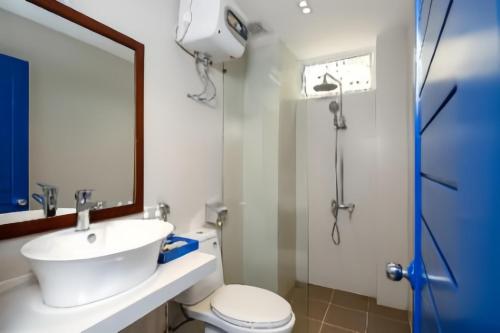 een badkamer met een wastafel, een toilet en een douche bij Lucia Beach Hotel in Da Nang