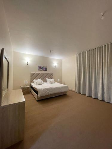 a bedroom with a bed and a large window at Seer Furnished Apartments صير للشقق المفروشة in Abu Dhabi