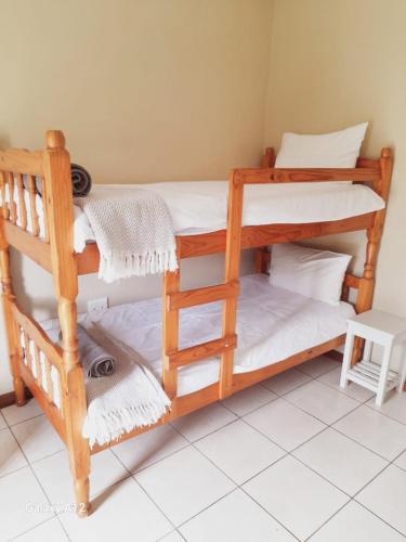 two bunk beds in a room with white towels at Bazley High Rocks Top Cottage in Bazley Beach