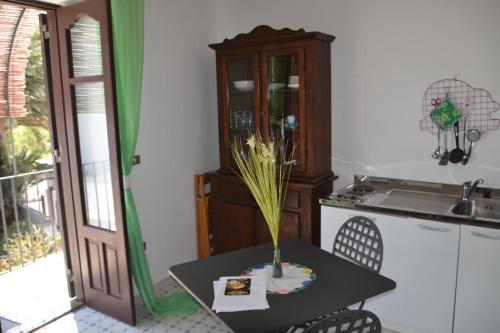 una cocina con una mesa con un jarrón. en Ingrid Romantic House, en Stromboli