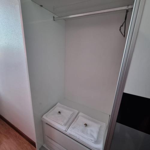 a white refrigerator with two white towels in it at Habitación confort 