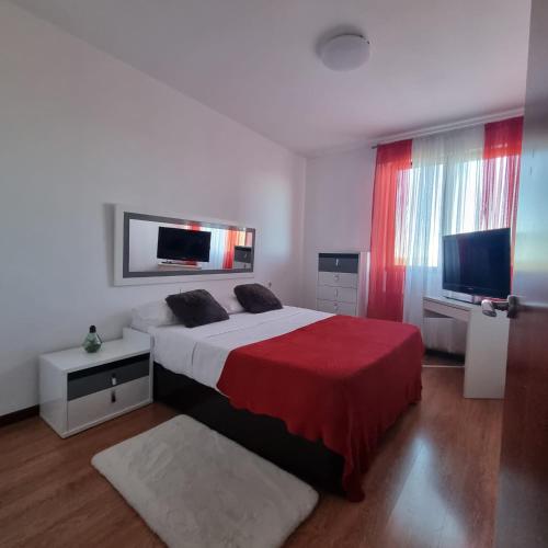 een slaapkamer met een bed en een flatscreen-tv bij Habitación confort 