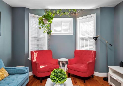 two red chairs in a living room with blue walls at Colorful, Comfy & Modern - Close to NYC - Parking! in Mount Vernon