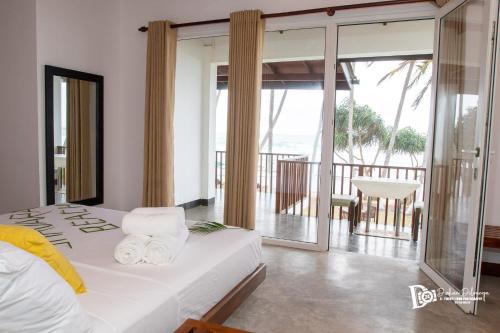 Schlafzimmer mit einem Bett und Meerblick in der Unterkunft Shavara Beach in Ahangama