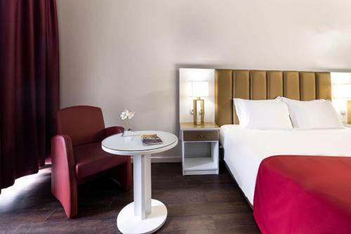Habitación de hotel con cama, mesa y silla en Hotel Estacão - Braga en Braga