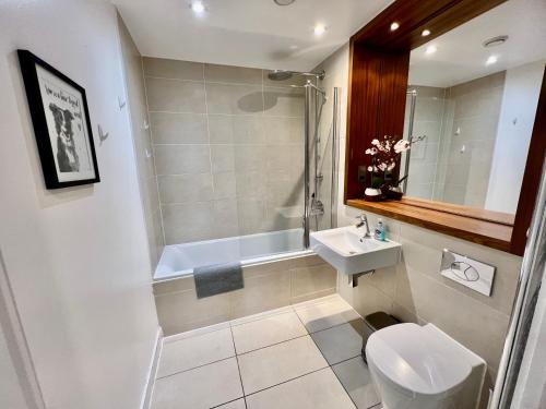 e bagno con servizi igienici, lavandino e doccia. di Home2home Serviced Apartment a Cambridge