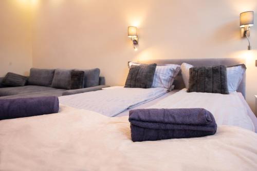 two beds in a room with a couch at GrigorasNCo Studio Apartments in Budapest