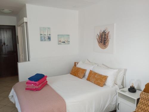 sypialnia z białym łóżkiem z bagażem w obiekcie Apartamento Te Miti w Puerto del Carmen