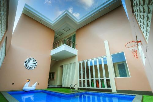 una casa con piscina y canasta de baloncesto en The Horizontal Hotel Pacitan, en Pacitan