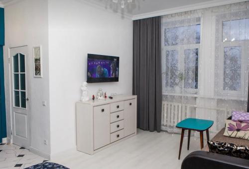 a living room with a dresser and a tv on the wall at VIP apart 752 in Tbilisi City