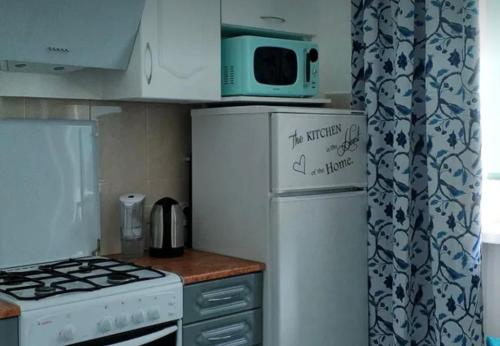 a kitchen with a microwave on top of a refrigerator at VIP apart 752 in Tbilisi City