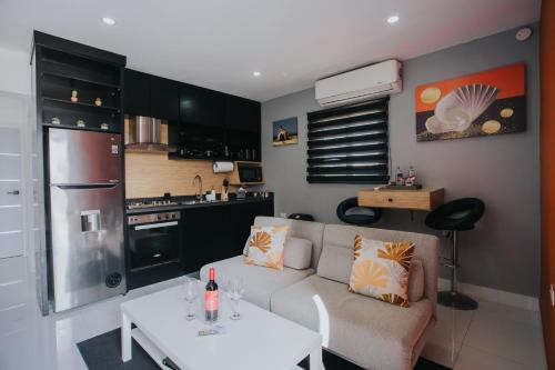 uma sala de estar com um sofá, uma mesa e uma cozinha em Hidden Villa Aruba em Oranjestad