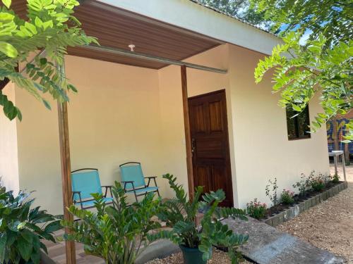two blue chairs sitting in front of a house at Jardines del Golfo in Lepanto