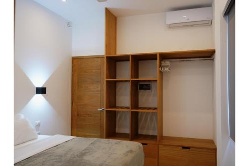 1 dormitorio con 1 cama y armario de madera en Appartement à Monte Buena Vista en Las Terrenas