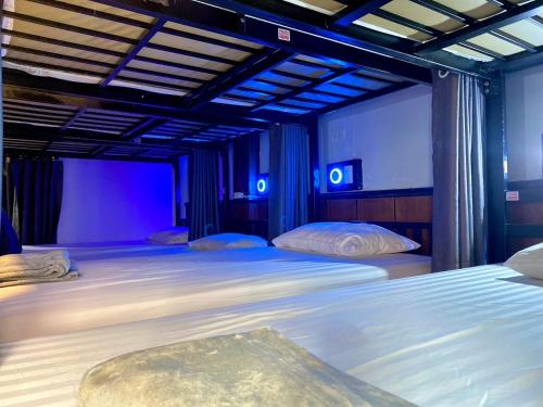 1 Schlafzimmer mit 2 Betten und blauen Lichtern in der Unterkunft LONGDOO Hostel in Ko Phi Phi