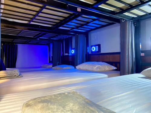 a bedroom with two beds with blue lights at LONGDOO Hostel in Phi Phi Don