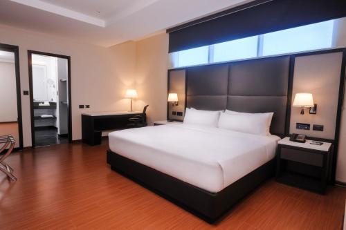 a bedroom with a large white bed and a desk at Hilton Garden Inn Lima Surco in Lima