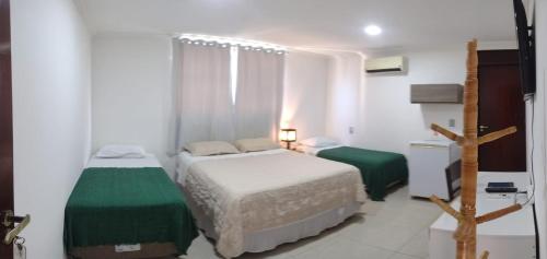 a small bedroom with two beds and a window at Pousada Espaco Luz do Sol Beira-Mar in João Pessoa