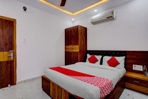 a bedroom with a large bed with red pillows at Oxygen in Rānchī