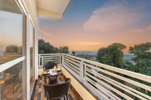 balcone con tavolo, sedie e vista di Stone Wood Mountain Resort, Dharamshala a Dharamshala