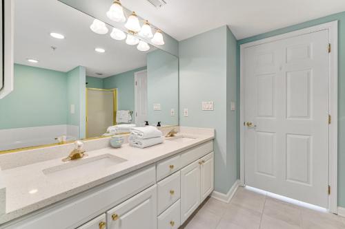 a bathroom with two sinks and a large mirror at Surf Watch 104 in Ocean City