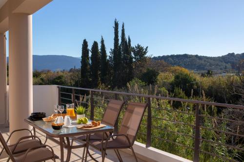 a patio with a table and chairs on a balcony at Amelie's Luxe Apartments in Lefkada Town