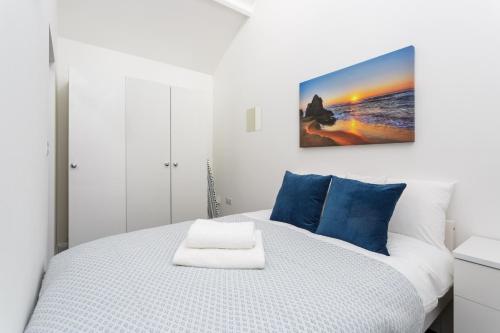 a bedroom with a white bed with blue pillows at Stylish Self-Contained Annex near City Centre in Southampton