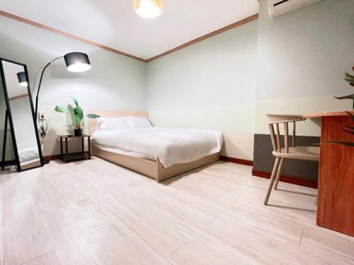 a bedroom with a bed and a desk and a chair at Jnineguesthouse in Seoul