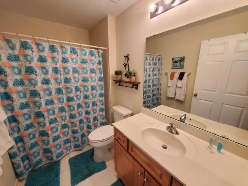 a bathroom with a sink and a toilet and a shower curtain at Seaside at Anastasia 306 in Saint Augustine Beach