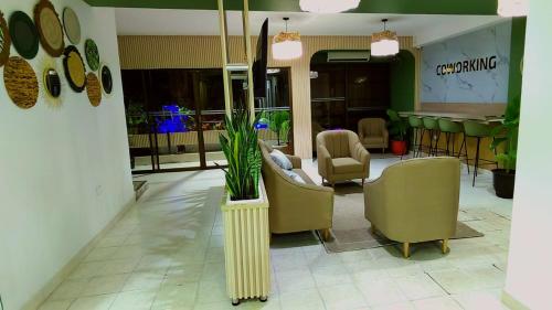 a lobby with chairs and a plant in a vase at HOTEL BOHO BOUTIQUE in Quibdó